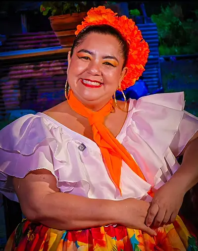 Bailadora juvenil sonriendo con vestuario tradicional amarillo.