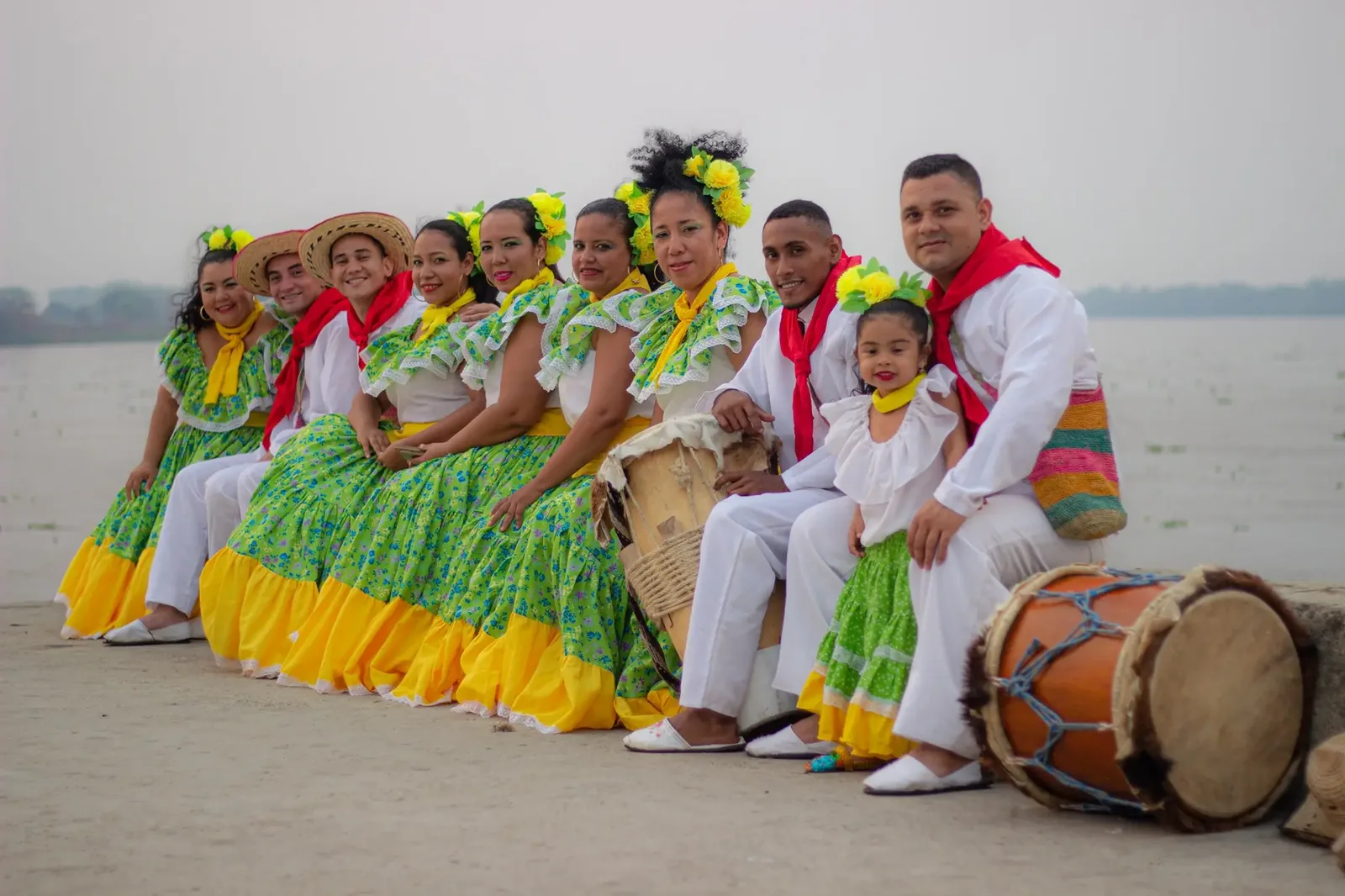 Bailadoras y bailadores de la fundación en plena danza tradicional, con faldas amarillas en movimiento.
