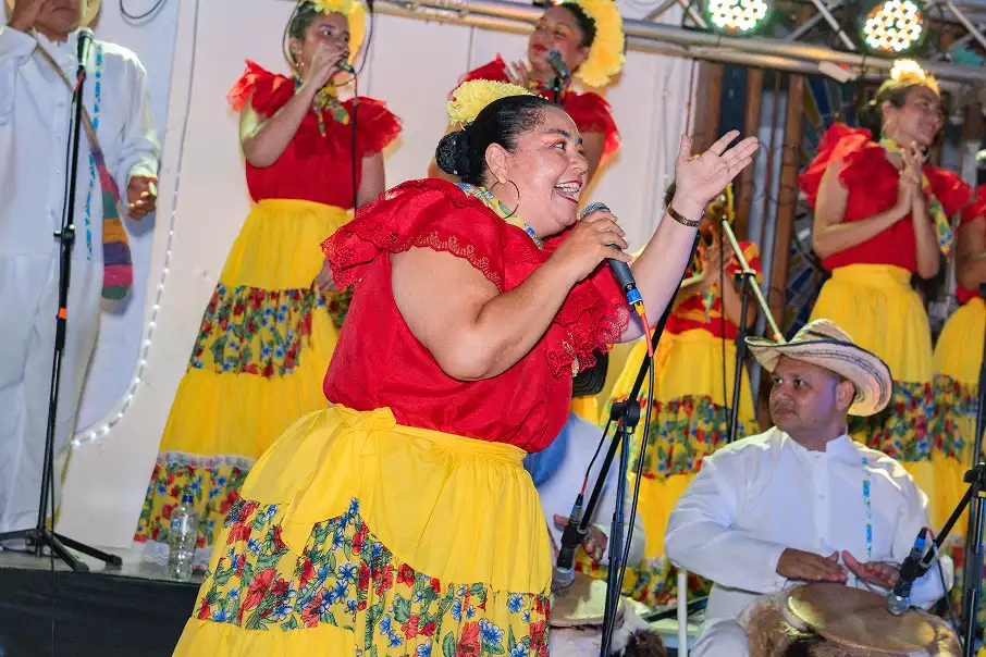 Tambora y guacharaca tradicionales sobre un fondo cálido de textura papel.